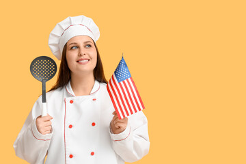 Young female chef with USA flag and skimmer spoon on orange background