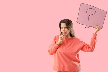 Thoughtful young woman holding speech bubble with question mark on pink background