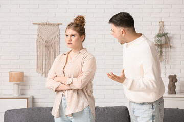 Angry husband scolding his wife at home