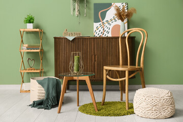 Interior of living room with chair and green candle on table