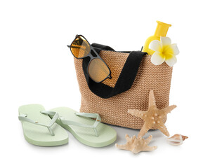 Bag with bottle of sunscreen cream and beach accessories isolated on white background