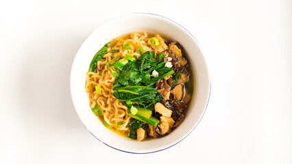 Top view of delicious noodle dish with chicken broth and toppings of boiled caisim vegetables,...