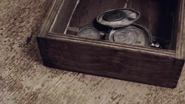 The several vintage silver coins  in the wooden box