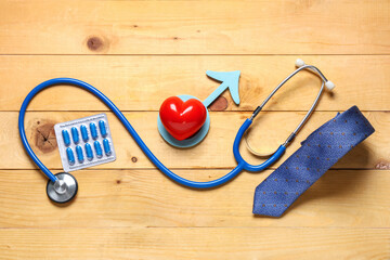 Male sign with heart, stethoscope, pills and tie on wooden background. Prostate cancer awareness...