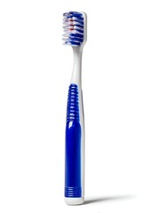 Colorful plastic toothbrush with blue bristles and soft rubber handle, minimal front view design isolated on white background.