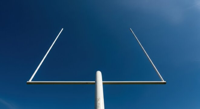 American football goal posts against a clear blue sky