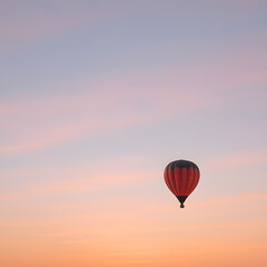 Obraz premium Red Hot Air Balloon Soaring in Pastel Sunset Sky, Freedom Concept.
