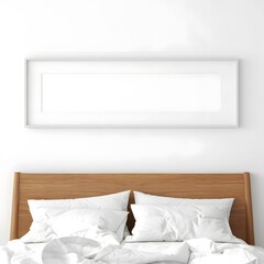 A minimalist bedroom scene featuring a crisp white wall with a long empty horizontal picture frame above a simple wooden headboard with two neatly made white pillows