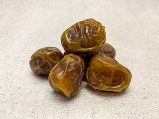 A vibrant close-up of a pile of delicious Sukkari dates (sukari dates), showcasing their golden-brown hue.