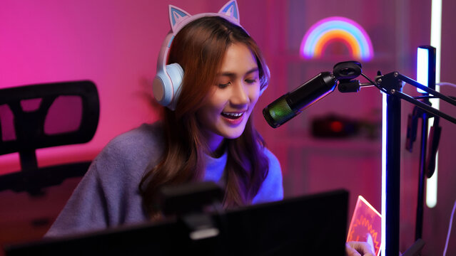 Female Asian streamer live streaming gaming setup neon light studio creative space entertainment - Powered by Adobe