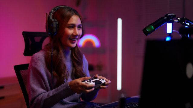 Young Asian woman streamer playing video games online live stream gaming setup entertainment technology content creator