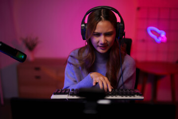 Asian young adult woman professional streamer plays video game online home studio setup