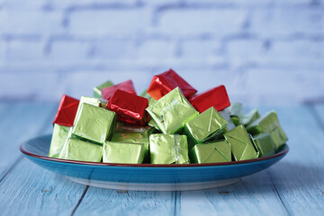 Colorful candy squares arranged on a blue plate