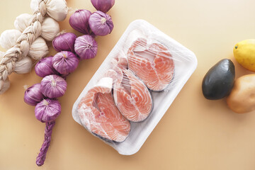 Fresh salmon fillets with garlic and vegetables on display