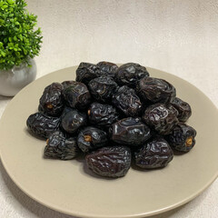 A bountiful plate of authentic Ajwa dates, known for their unique dark color and rich flavor.