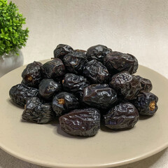 A bountiful plate of authentic Ajwa dates, known for their unique dark color and rich flavor.