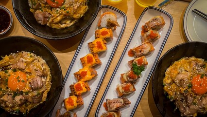 Japanese Feast Extravaganza: A vibrant top-down shot showcasing an appetizing spread of Japanese cuisine, including beautifully arranged sushi rolls and savory donburi bowls with egg yolks.