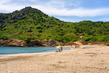 Tourists relaxing on Sa Figu beach in Sardinia, italy