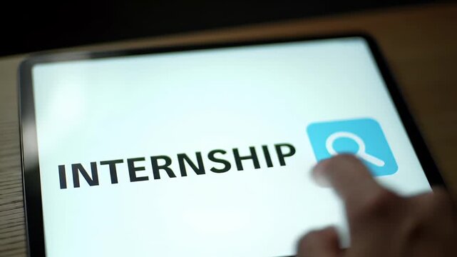 Hand Interacting With Internship Search Function on a Tablet Featuring a Blue Magnifying Glass Icon with Bright Screen Glare and Black Background