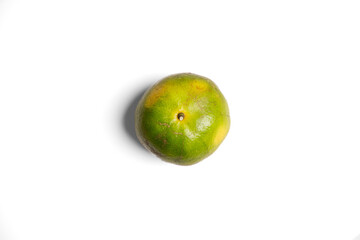 Top-down flat lay of a Thai green tangerine with a bold shadow for a modern, graphic look. Perfect for unique food, travel, and design themes. An authentic and stylish choice for your project.
