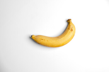 A single ripe banana, perfectly isolated on a clean white background. This beautifully simple and natural shot is a versatile choice for health, diet, and food designs. An essential fruit image.