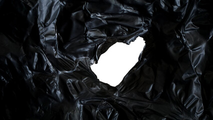 Wrinkled texture of black plastic with ripped hole isolated on transparent background