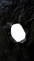 Black plastic with ripped hole in the middle of the surface isolated on transparent background