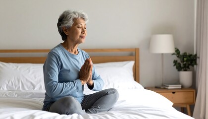 Senior woman meditating in bedroom