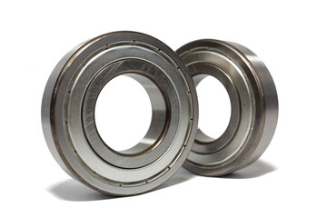 Two shiny metal ball bearings are isolated on a crisp white background.
