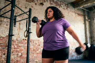 Confident Plus-Size Woman Lifting Dumbbells in Modern Gym with Realistic Workout Lighting