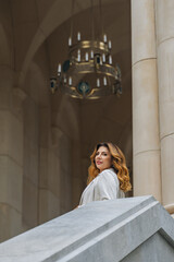 Woman Chandelier Castle - A woman in a white dress stands on a stone staircase in a grand castle...