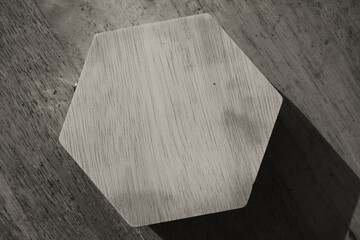 Hexagonal wooden jewelry box and shadow in monochrome. Black and white photo of isolated hexagonal wooden box. Single objects. Texture and silhouette of jewelry box. Negative space.