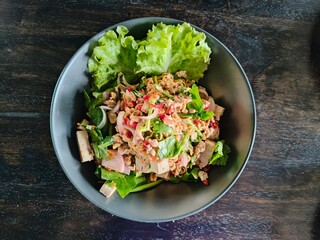 Yum Mu Yo served with salad on a white plate