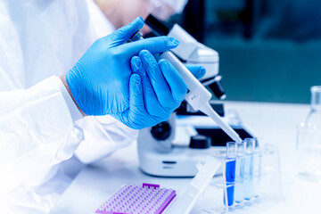 Closeup hand of scientist filling chemical through in test tubes in laboratory. Research,...