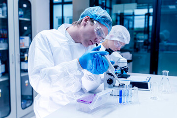 Closeup Scientist filling chemical through in test tubes in laboratory. Research, experiment and...