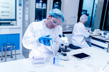 Young professional scientist serious researcher organizing, sorting or making a discovery through test tubes.