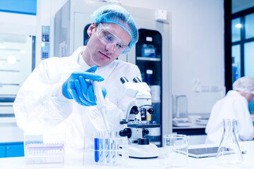 Closeup Scientist filling chemical through in test tubes in laboratory. Research, experiment and...
