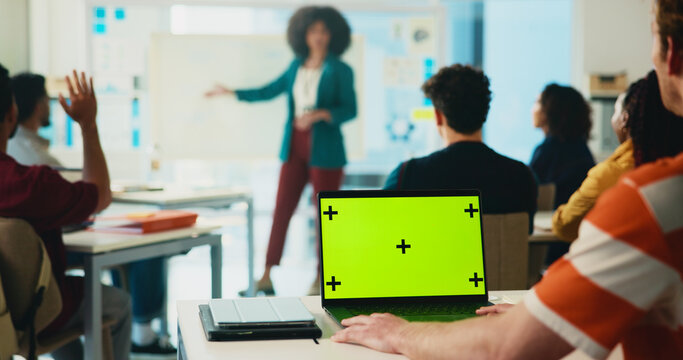 Green screen, laptop and learning with students in classroom for college portal, lecture and lesson notes. University, education and teaching with people on campus for assignment research and mockup - Powered by Adobe
