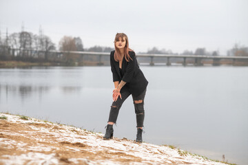 Portrait of a young beautiful red-haired girl in early winter outdoors.