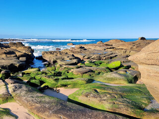 Ocean waves crashing over an eroded rock platform and boulders at Soldiers Point New South Wales...
