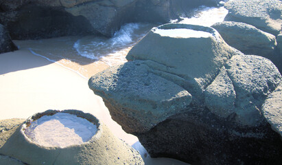 Strange raised rock pool on the wave cut platform at Soldiers Point New South Wales Australia. Eroded geological feature with a small pool in it.