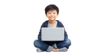 A young boy is sitting on the floor with a laptop in front of him