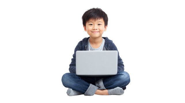 A young boy is sitting on the floor with a laptop in front of him