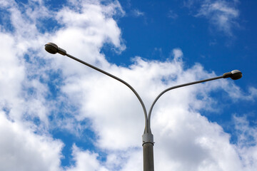 A street light stands tall against a cloudy blue sky during evening