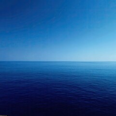 Fototapeta premium Vast expanse of deep blue ocean meeting a clear, pale blue sky