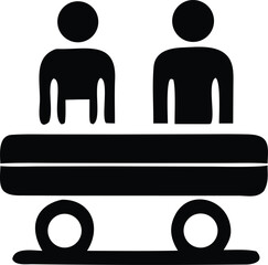 Simple black silhouette icon depicting two figures seated at a table with wheels below suggesting transportation or a mobile setup