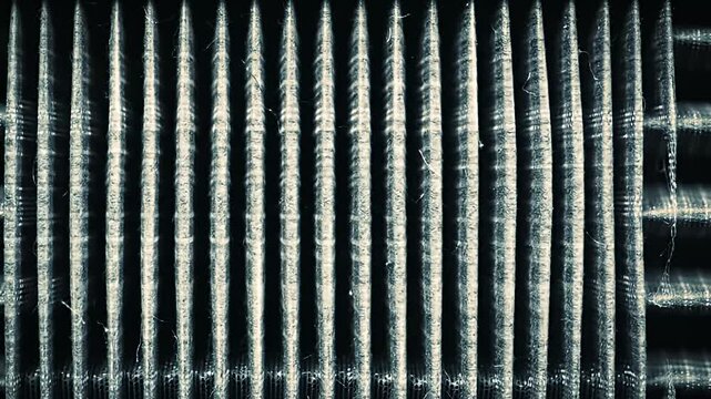 Close-up of a corrugated material with a black background and teal, grainy texture