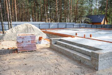 Concrete slab of foundation of house with laid pipes start of construction on project. Construction...