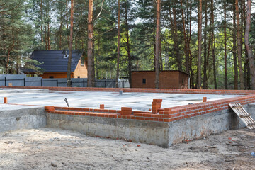 Concrete slab of foundation of house with laid pipes start of construction on project. Construction...