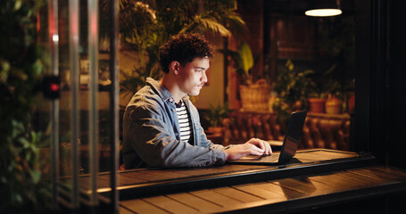 Night, creative and man with laptop, cafe and freelance project on website, app and email...
